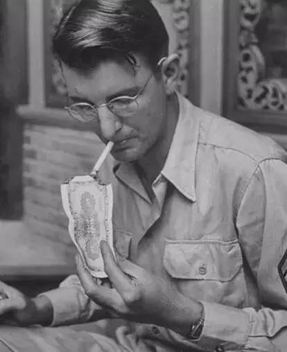 一位美国大兵在用钞票点烟,这在当时并不奢侈